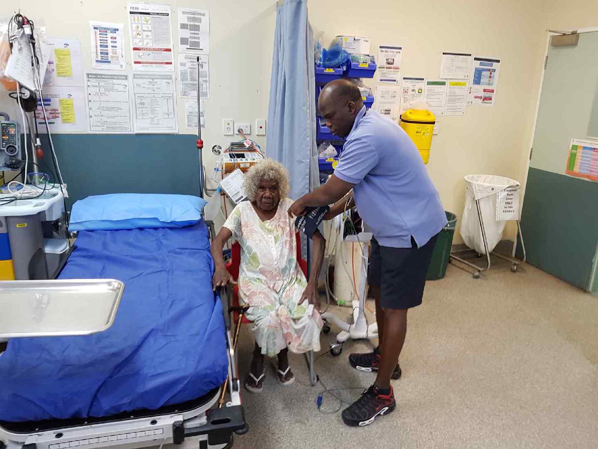 Health professional checking a patient's blood pressure in a clinic room.