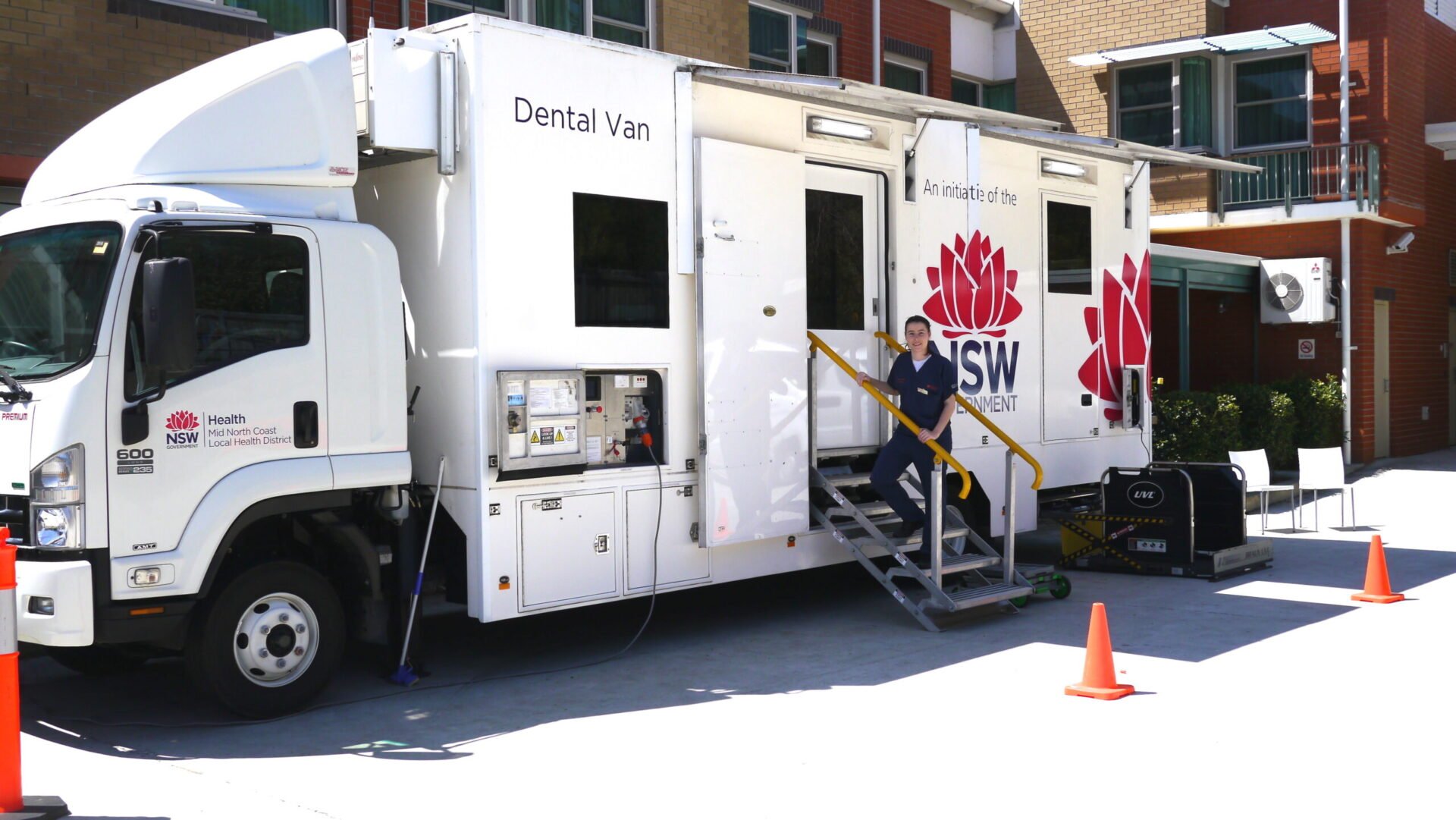 Person walking up the steps of a NSW Government dental van.