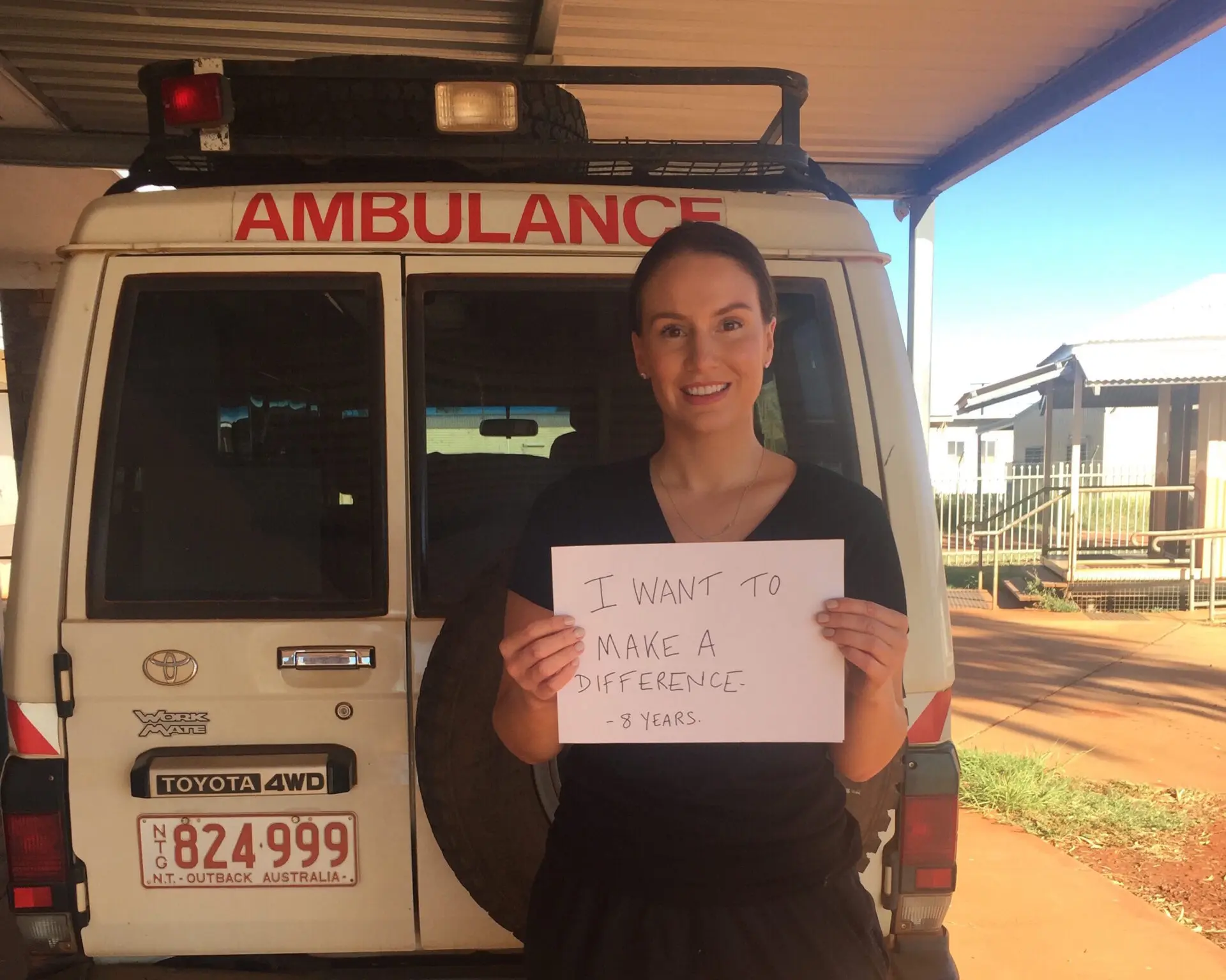 Ali holding a sign that reads: I want to make a difference. 8 years.