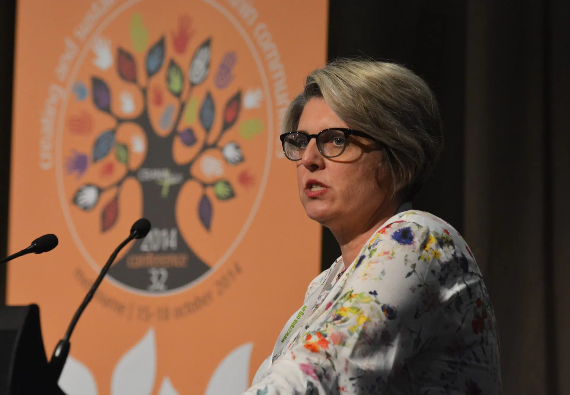 Kathryn speaking into a lecturn microphone.