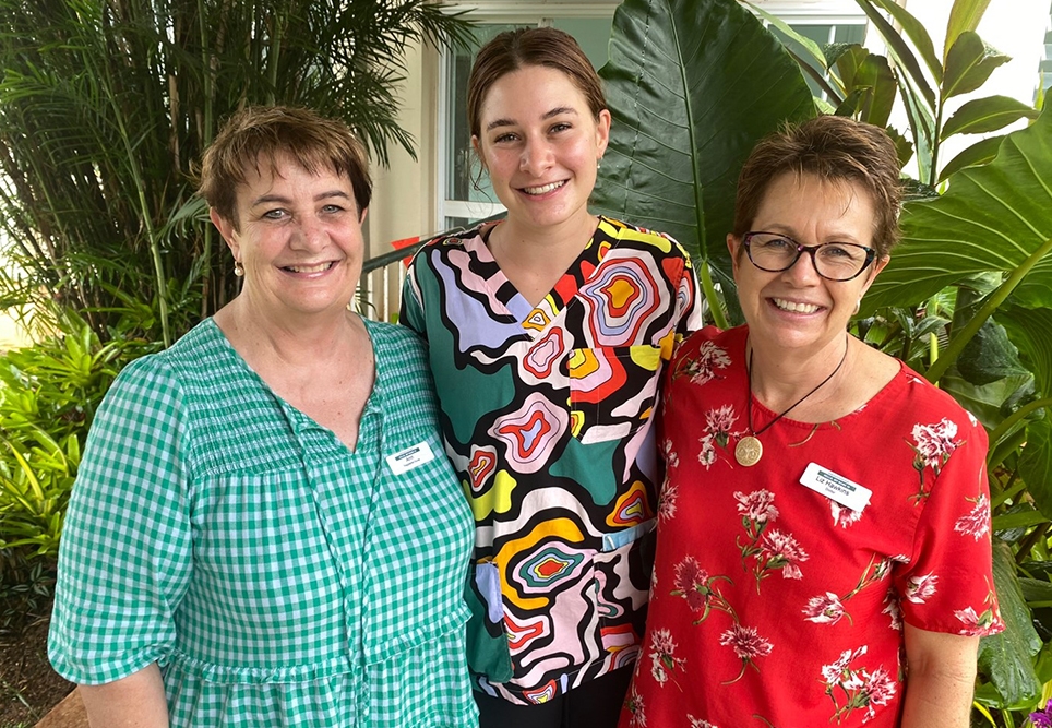 Three people stood together smiling