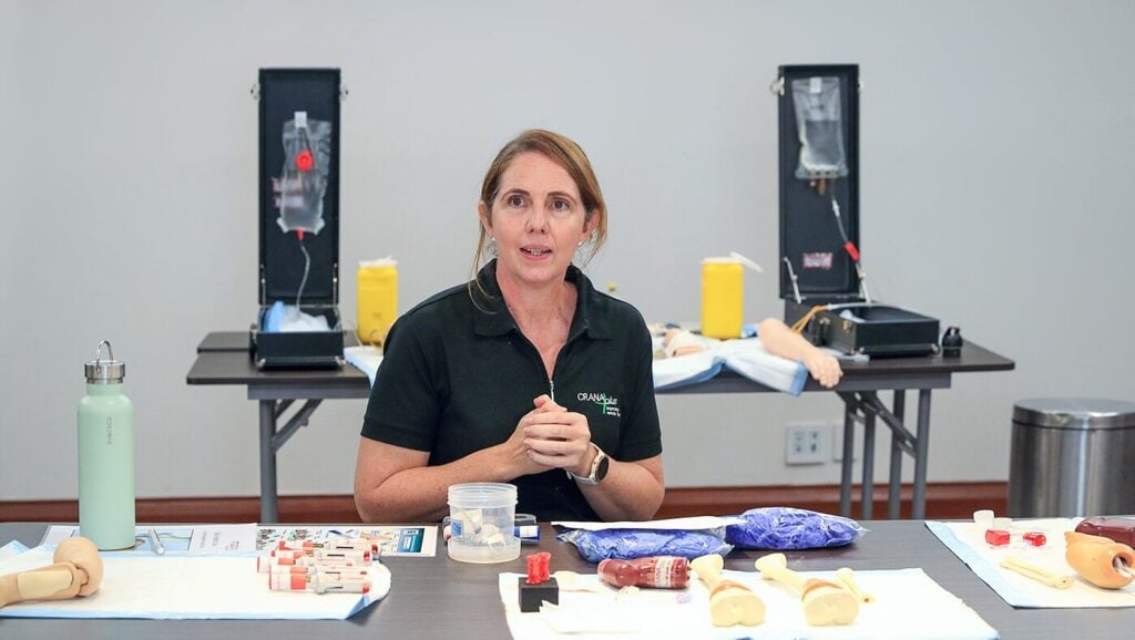 Person sat at table with training equipment, speaking