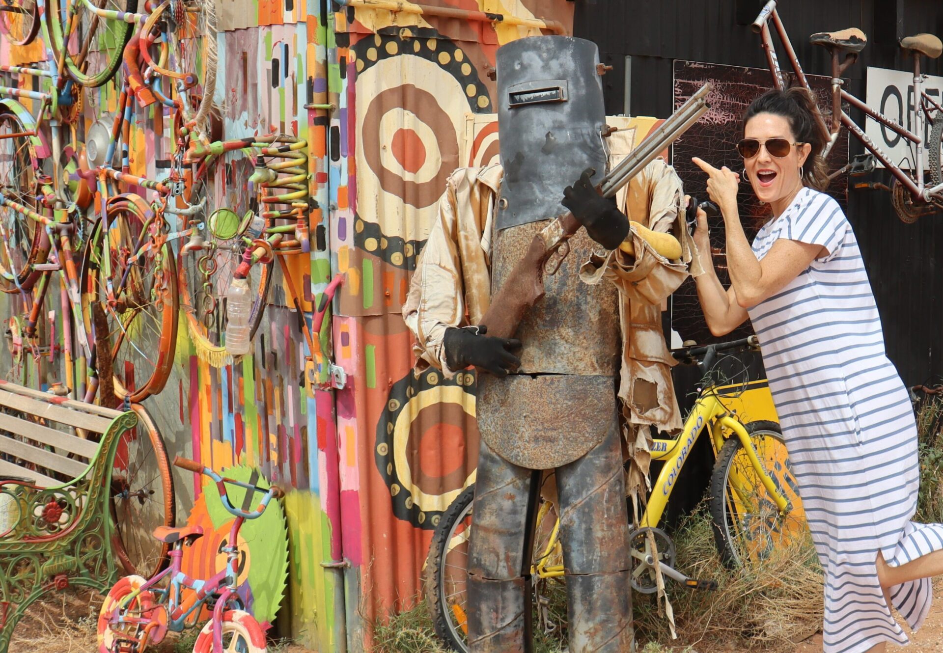 Woman pointing with suprised face next to Ned Kelly statue.