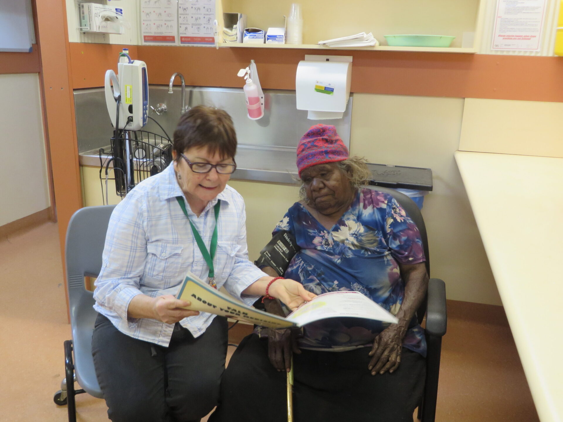 Woman reading to another woman in a clinic room
