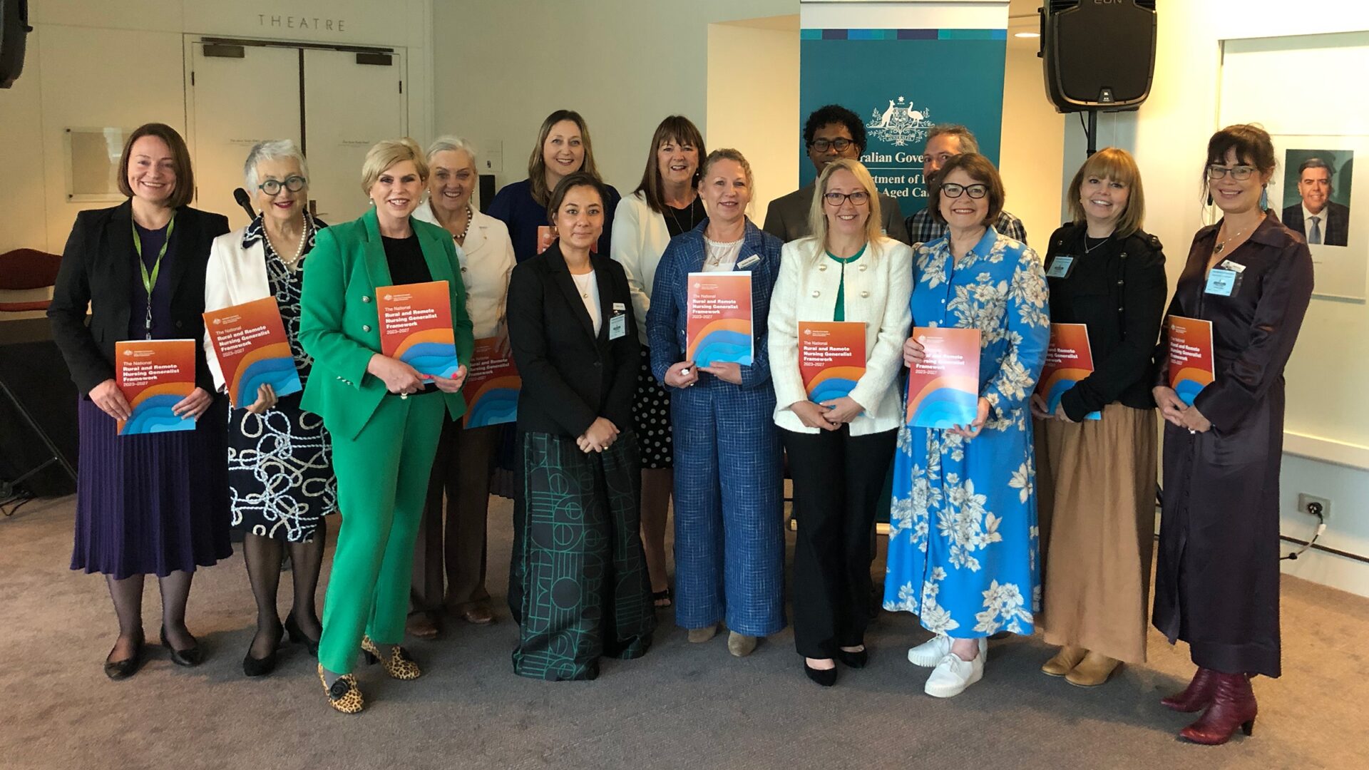 Group of people standing and holding the National Rural and Remote Nursing Generalist Framework