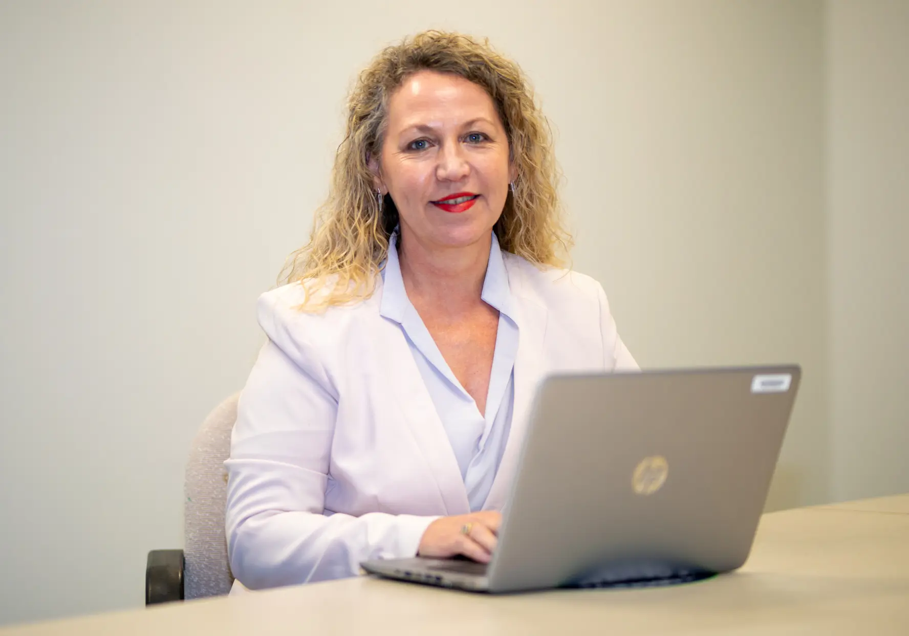Woman sitting in front of a laptop at a desk.