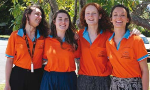 Group of people in bright orange polo shirts.