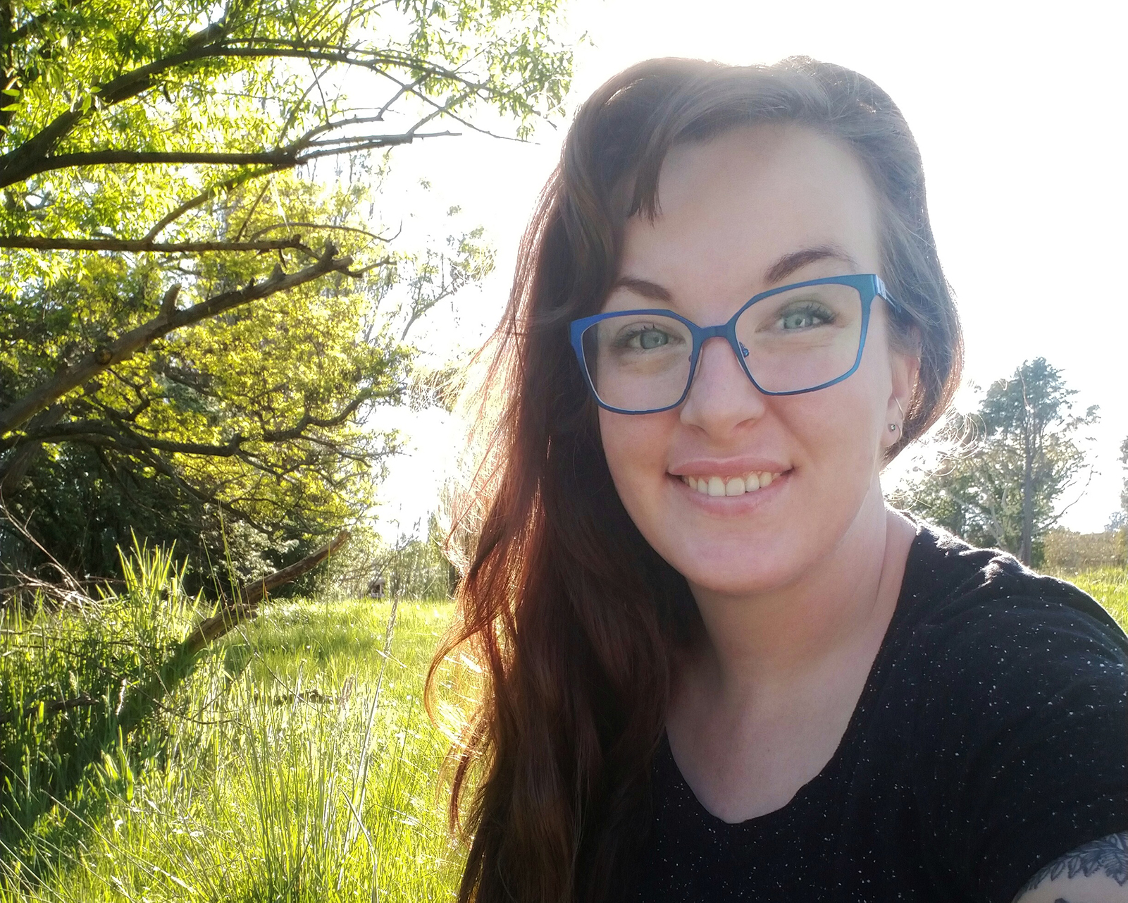 Tilley Wilson. Tilly has long brown hair, and blue rimmed glasses.