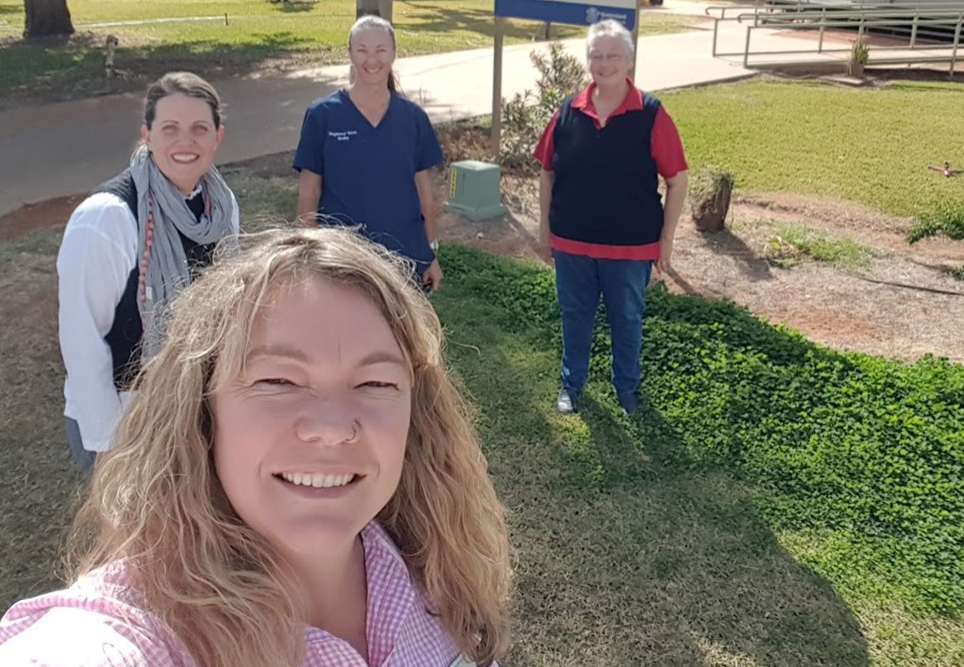 Danielle smiling with three people behind her